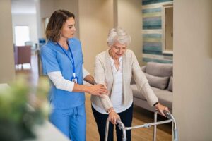 A senior resident chats with a staff member in a comfortable common area with natural light.