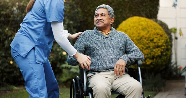 A senior and family member talking together in a comfortable, home-like living space with personal touches.